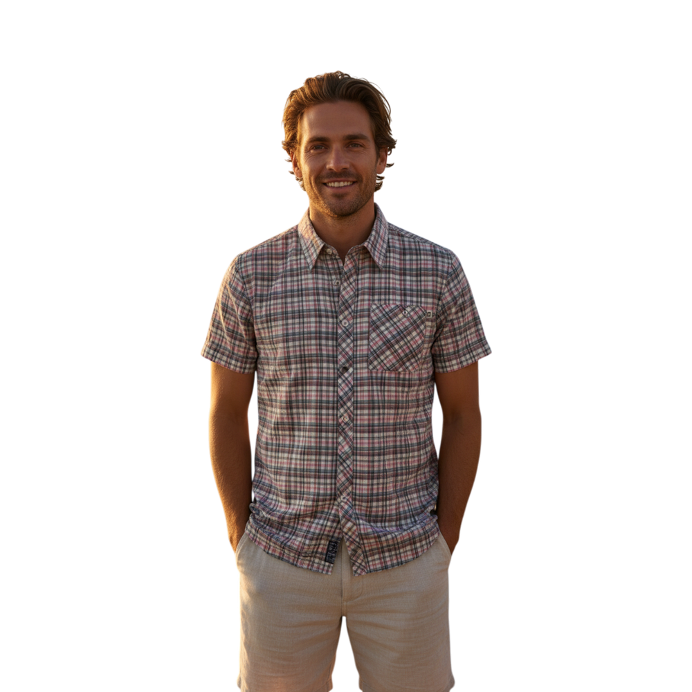 Glas Apparel Hayes short sleeve shirt in a multi-colored plaid cotton pattern worn by a man on a beach at sunset.